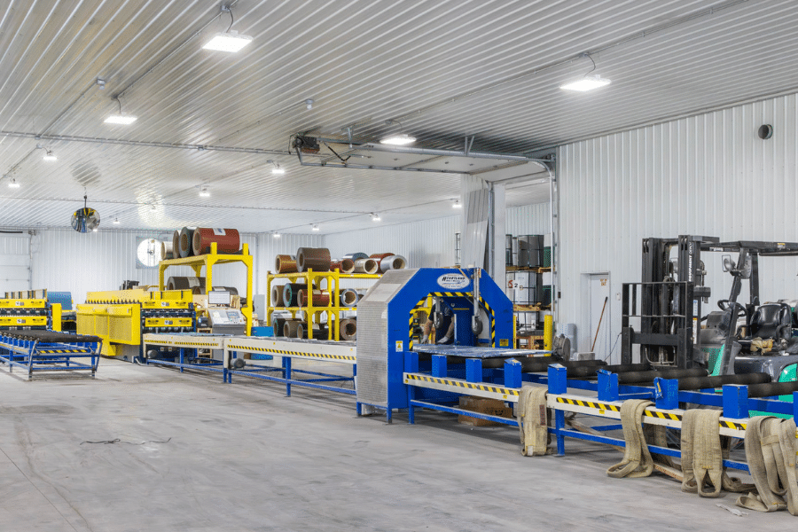 yellow and blue machines that wrap metal panels to get them assembled for 40x40 pole barn garage kits